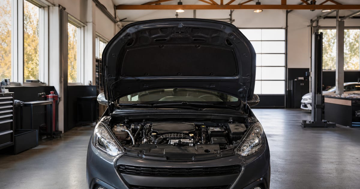 Peugeot compacte au capot ouvert dans un atelier lumineux, sans personne