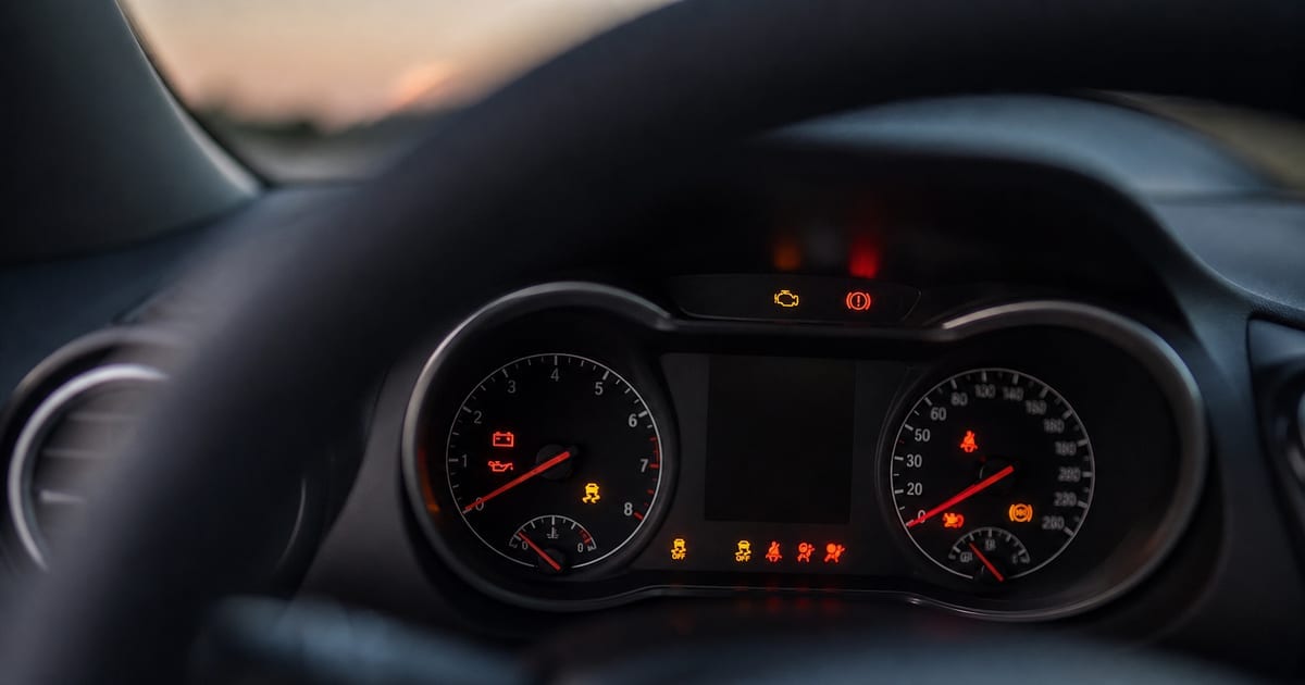 Dacia Sandero stationnée devant un atelier automobile, capot fermé et sans conducteur